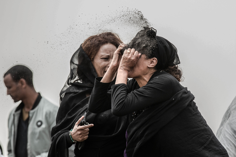 An Ethiopian relative of a crash victim throws dirt in her own face after realising that there is nothing physical left of her loved one, as she mourns at the scene where the Ethiopian Airlines Boeing 737 Max 8 crashed shortly after takeoff on Sunday